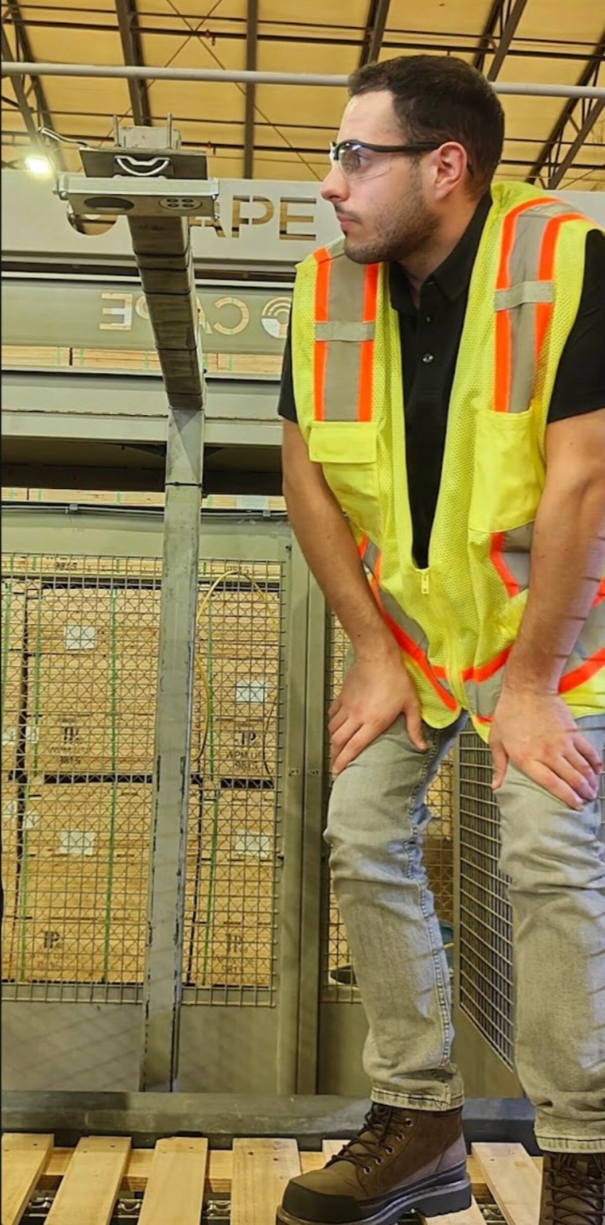 Operator standing beside installed L-Frame portal with AI camera mounted at top arm