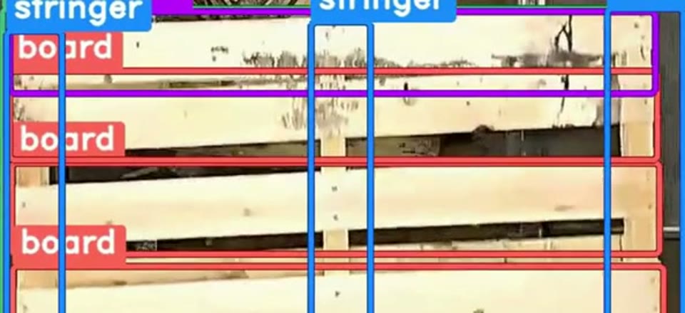 Overhead camera frame of a 48 by 40 GMA pallet deck in which a board under the lead board sits skewed, leaving an uneven gap