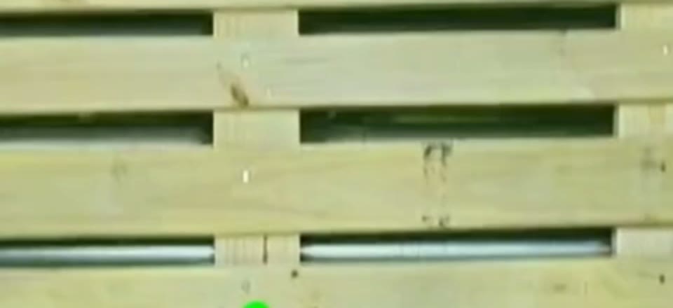 Overhead camera frame of the deck boards of a new 48 by 40 GMA pallet, with the nail heads visible over the centre stringer